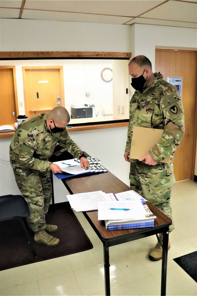 Deputy Garrison Commander Lt. Col. Alexander Carter receives paperwork to complete in order to receive a COVID-19 vaccination Jan. 26, 2021, at the Fort McCoy Health Clinic during the first round of COVID-19 vaccinations at Fort McCoy, Wis. Carter...