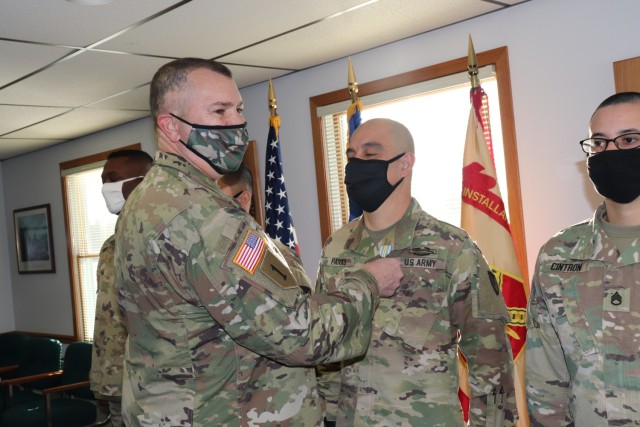 Garrison Commander Col. Michael D. Poss presents the Military Outstanding Volunteer Service Medal (MOVSM) to Sgt. 1st Class Gregory Parks of U.S. Army Garrison-Fort McCoy’s Headquarters and Headquarters Company on Jan. 22, 2021, in building 100...