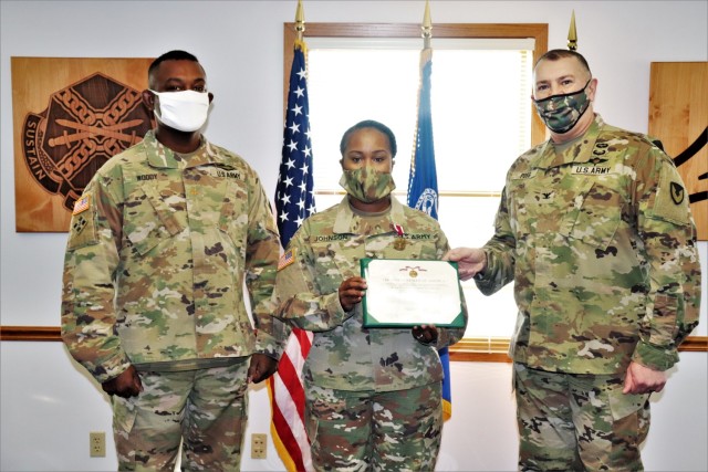 Fort McCoy Garrison Commander Col. Michael D. Poss (right) presents Master Sgt. Cynthia P. Johnson with an Army Meritorious Service Medal on Jan. 22, 2021, at the garrison headquarters building at Fort McCoy, Wis. Johnson earned the medal for...