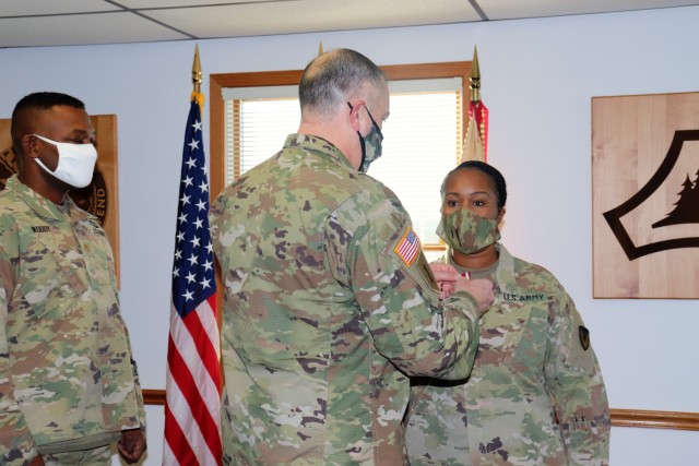 Fort McCoy Garrison Commander Col. Michael D. Poss presents Master Sgt. Cynthia P. Johnson with an Army Meritorious Service Medal on Jan. 22, 2021, at the garrison headquarters building at Fort McCoy, Wis. Johnson earned the medal for meritorious service with Fort McCoy Garrison between 2018 and 2021. (U.S. Army Photo by Scott T. Sturkol, Public Affairs Office, Fort McCoy, Wis.)