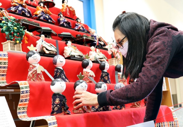 Sabrina Tsai, manager of the Camp Zama Arts and Crafts Center, arranges Japanese “Hinamatsuri” dolls on a display at the Sagamihara Family Housing Area Library, SFHA, Japan, Feb. 11.
