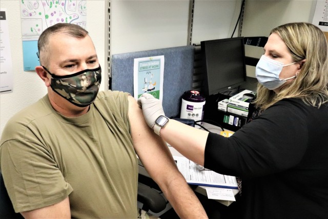 Garrison Commander Col. Michael D. Poss receives a COVID-19 vaccination Jan. 26, 2021, from Erica Miller, a registered nurse with the Fort McCoy Health Clinic, during the first round of COVID-19 vaccinations at Fort McCoy, Wis.  Poss was the first...