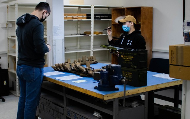 U.S. Army Sgt. Joseph Chiddix and Pfc. Jennifer Vaughn-Glashoff, armorers with the 317th Support Maintenance Company, 18th Combat Sustainment Support Brigade, 16th Sustainment Brigade, out of Baumholder, Germany, inspect Sig Sauer M17 pistols during an annual weapons inspection at Camp Bondsteel, Kosovo, on Feb. 9, 2021. The 317th SMC travelled from Germany to help Soldiers deployed in support of Kosovo Force 28 complete their mandatory annual inspection. (U.S. Army National Guard photo by Sgt. Jonathan Perdelwitz)