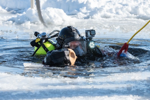 A firefighter with the Directorate of Emergency Services Fire Department dive team completes dive training under ice Feb. 3, 2021, at Big Sandy Lake on South Post at Fort McCoy, Wis. The department conducts surface and dive training with ice-covered lakes on post annually. (U.S. Army Photo by Cedar Wolf, Fort McCoy Multimedia-Visual Information Office)