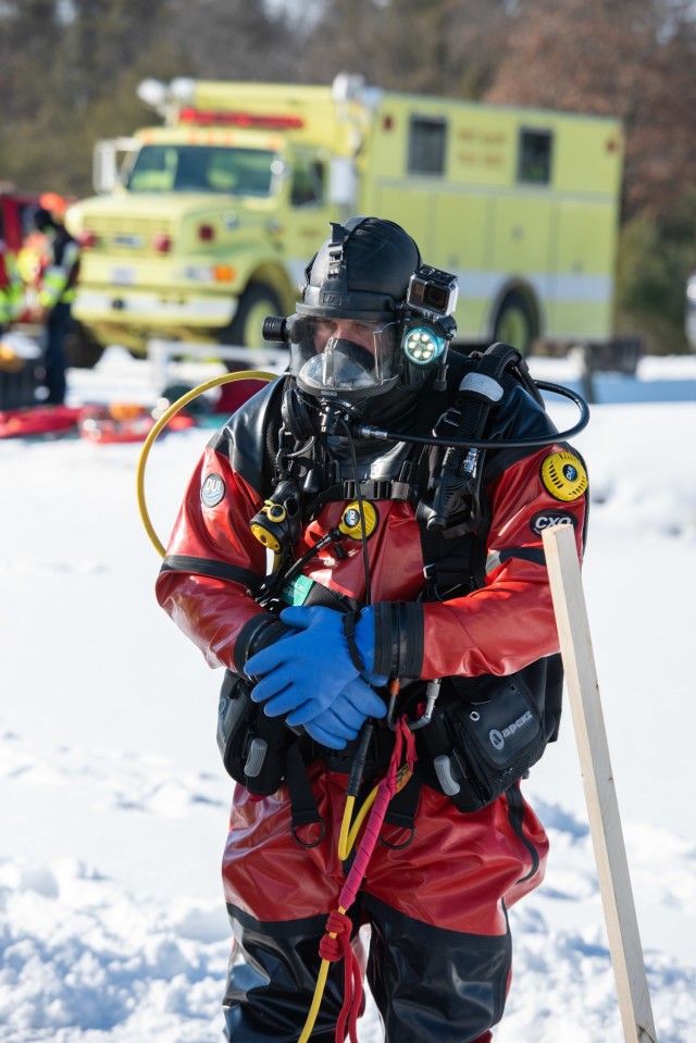 A firefighter with the Directorate of Emergency Services Fire Department dive team prepares for dive training under ice Feb. 3, 2021, at Big Sandy Lake on South Post at Fort McCoy, Wis. The department conducts surface and dive training with ice-covered lakes on post annually. (U.S. Army Photo by Cedar Wolf, Fort McCoy Multimedia-Visual Information Office)