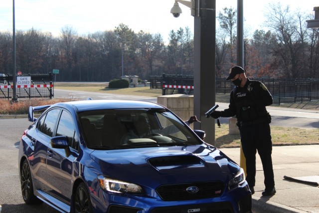 A police officer with the Directorate of Emergency Services Police Department scans an identification card while practicing COVID-19 safety protocols Dec. 3, 2020, at Fort McCoy, Wis. Throughout the installation's pandemic response, which started...