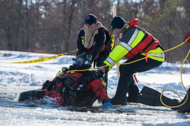 Firefighters with the Directorate of Emergency Services Fire Department dive team complete dive training under ice Feb. 3, 2021, at Big Sandy Lake on South Post at Fort McCoy, Wis. The department conducts surface and dive training with ice-covered lakes on post annually. (U.S. Army Photo by Cedar Wolf, Fort McCoy Multimedia-Visual Information Office)