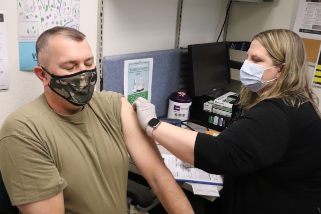 Garrison Commander Col. Michael D. Poss receives a COVID-19 vaccination Jan. 26, 2021, from Erica Miller, a registered nurse with the Fort McCoy Health Clinic, during the first round of COVID-19 vaccinations at Fort McCoy, Wis.  Poss was the first Soldier to receive the vaccine at the post. The effort was the beginning of many rounds of vaccinations at the installation. The COVID-19 vaccine is now available due in large part to the Department of Defense effort for Operation Warp Speed to get vaccines to the American people. (U.S. Army Photo by Scott T. Sturkol, Public Affairs Office, Fort McCoy, Wis.)