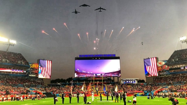 The U.S. Armed Forces Color Guard salutes as the U.S. Air Force flyover crosses the Raymond James Stadium at Super Bowl LV in Tampa, Florida, Feb. 7, 2021. The U.S. Armed Forces Color Guard is comprised of service members from the ceremonial guard units stationed in and around Washington, D.C. U.S. Army photo by Maj. Stephen Von Jett.