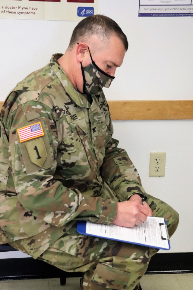 Garrison Commander Col. Michael D. Poss fills out paperwork in order to receive a COVID-19 vaccination Jan. 26, 2021, at the Fort McCoy Health Clinic during the first round of COVID-19 vaccinations at Fort McCoy, Wis. Poss was among several people to receive the vaccine at the post. The effort was the beginning of many rounds of vaccinations at the installation. The COVID-19 vaccine is now available due in large part to the Department of Defense effort for Operation Warp Speed to get vaccines to the American people. (U.S. Army Photo by Scott T. Sturkol, Public Affairs Office, Fort McCoy, Wis.)