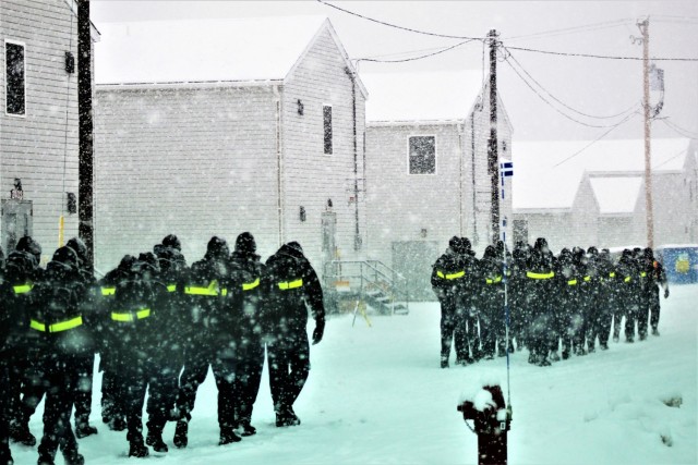 U.S. Navy recruits walk on the cantonment area in a snowstorm Feb. 4, 2021, at Fort McCoy, Wis. The Navy’s Recruit Training Command (RTC) of Great Lakes, Ill., worked with the Army in 2020 at Fort McCoy so the post could serve as a restriction-of-movement (ROM) site for Navy recruits prior to entering basic training. Additional personnel support from the Navy’s Great Lakes, Ill., Millington, Tenn., and Washington, D.C., sites deployed to McCoy to assist RTC in conducting the initial 14-day ROM to help reduce the risk of bringing the coronavirus to RTC should any individual be infected. More than 40,000 recruits train annually at the Navy’s only boot camp. This is also the first time Fort McCoy has supported the Navy in this capacity. Fort McCoy’s motto is to be the “Total Force Training Center.” (U.S. Army Photo by Scott T. Sturkol, Public Affairs Office, Fort McCoy, Wis.)