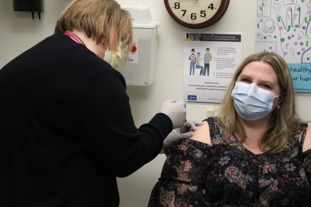 Health Technician Heather Green with the Fort McCoy Health Clinic gives a COVID-19 vaccination to Erica Miller, a registered nurse with the clinic, on Jan. 26, 2021, during the first round of COVID-19 vaccinations at Fort McCoy, Wis. Several people received the vaccine at the post Jan. 26. The effort was the beginning of many rounds of vaccinations at the installation. The COVID-19 vaccine is now available due in large part to the Department of Defense effort for Operation Warp Speed to get vaccines to the American people. (U.S. Army Photo by Scott T. Sturkol, Public Affairs Office, Fort McCoy, Wis.)