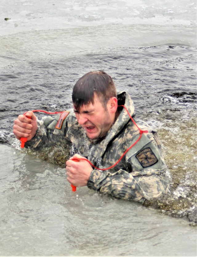 A Fort McCoy Cold-Weather Operations Course (CWOC) Class 21-02 student participates in cold-water immersion training Jan. 15, 2021, at Big Sandy Lake on South Post at Fort McCoy, Wis. CWOC students are trained on a variety of cold-weather subjects, including snowshoe training and skiing as well as how to use ahkio sleds and other gear. Training also focuses on terrain and weather analysis, risk management, cold-weather clothing, developing winter fighting positions in the field, camouflage and concealment, and numerous other areas that are important to know in order to survive and operate in a cold-weather environment. The training is coordinated through the Directorate of Plans, Training, Mobilization and Security at Fort McCoy. (U.S. Army Photo by Scott T. Sturkol, Public Affairs Office, Fort McCoy, Wis.)