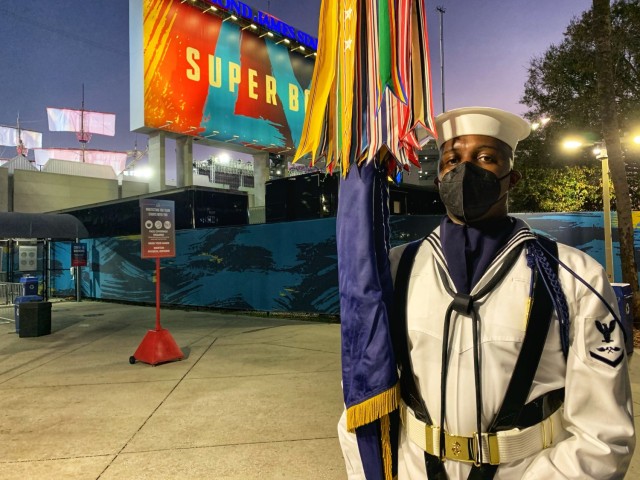 U.S. Navy Petty Officer 3rd Class James Hunter stands with the U.S. Navy service flag just after the color team’s performance at Super Bowl LV in Tampa, Florida, Feb. 7, 2021. The U.S. Armed Forces Color Guard is comprised of service members from the ceremonial guard units stationed in and around Washington, D.C. U.S. Army photo by Maj. Stephen Von Jett.