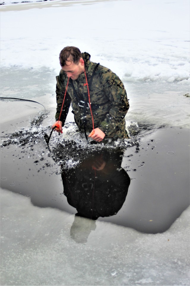 A Fort McCoy Cold-Weather Operations Course (CWOC) Class 21-02 student participates in cold-water immersion training Jan. 15, 2021, at Big Sandy Lake on South Post at Fort McCoy, Wis. CWOC students are trained on a variety of cold-weather subjects, including snowshoe training and skiing as well as how to use ahkio sleds and other gear. Training also focuses on terrain and weather analysis, risk management, cold-weather clothing, developing winter fighting positions in the field, camouflage and concealment, and numerous other areas that are important to know in order to survive and operate in a cold-weather environment. The training is coordinated through the Directorate of Plans, Training, Mobilization and Security at Fort McCoy. (U.S. Army Photo by Scott T. Sturkol, Public Affairs Office, Fort McCoy, Wis.)