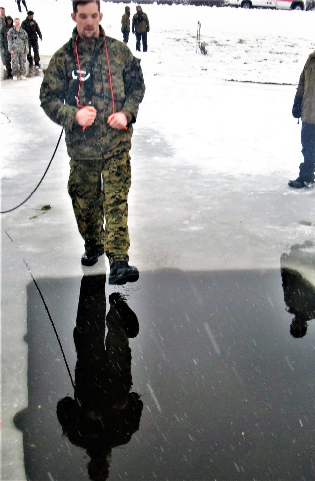 A Fort McCoy Cold-Weather Operations Course (CWOC) Class 21-02 student participates in cold-water immersion training Jan. 15, 2021, at Big Sandy Lake on South Post at Fort McCoy, Wis. CWOC students are trained on a variety of cold-weather subjects, including snowshoe training and skiing as well as how to use ahkio sleds and other gear. Training also focuses on terrain and weather analysis, risk management, cold-weather clothing, developing winter fighting positions in the field, camouflage and concealment, and numerous other areas that are important to know in order to survive and operate in a cold-weather environment. The training is coordinated through the Directorate of Plans, Training, Mobilization and Security at Fort McCoy. (U.S. Army Photo by Scott T. Sturkol, Public Affairs Office, Fort McCoy, Wis.)