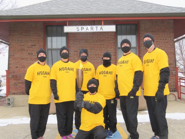 Members of the Fort McCoy, Wis., Army Ten-Miler team carry an event torch Jan. 29, 2021, as part of the opening ceremony of the Sparta Quest Winter Fest in Sparta, Wis. On Jan. 29, members of the team, along with Command Sgt. Maj. Paul Mantha,...