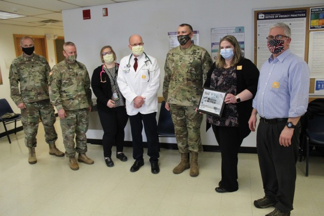 Members of the Fort McCoy Garrison command team are shown with staff members of the Fort McCoy Health Clinic on Jan. 26, 2021, to present the clinic staff with a certificate of appreciation to thank them for preparing the installation for the...