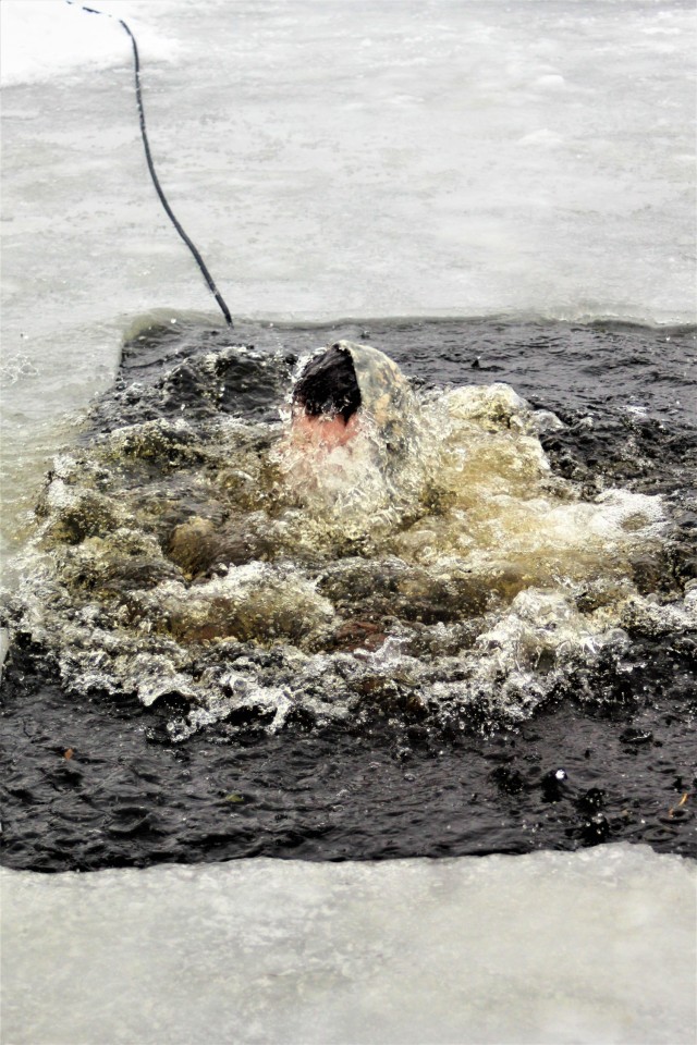 A Fort McCoy Cold-Weather Operations Course (CWOC) Class 21-02 student participates in cold-water immersion training Jan. 15, 2021, at Big Sandy Lake on South Post at Fort McCoy, Wis. CWOC students are trained on a variety of cold-weather subjects, including snowshoe training and skiing as well as how to use ahkio sleds and other gear. Training also focuses on terrain and weather analysis, risk management, cold-weather clothing, developing winter fighting positions in the field, camouflage and concealment, and numerous other areas that are important to know in order to survive and operate in a cold-weather environment. The training is coordinated through the Directorate of Plans, Training, Mobilization and Security at Fort McCoy. (U.S. Army Photo by Scott T. Sturkol, Public Affairs Office, Fort McCoy, Wis.)