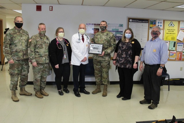 Members of the Fort McCoy Garrison command team are shown with staff members of the Fort McCoy Health Clinic on Jan. 26, 2021, to present the clinic staff with a certificate of appreciation to thank them for preparing the installation for the...