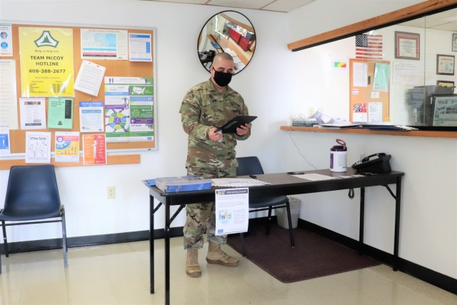 A Soldier prepares a reception area for people to sign in at the Occupational Health Clinic to receive a COVID-19 vaccination Jan. 28, 2021, at Fort McCoy, Wis. Fort McCoy first started completing COVID-19 vaccinations Jan. 26 at the installation with health care employees, garrison leadership, and first responders receiving the vaccinations. (U.S. Army Photo by Scott T. Sturkol, Public Affairs Office, Fort McCoy, Wis.)