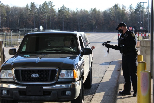 A police officer with the Directorate of Emergency Services Police Department scans an identification card while practicing COVID-19 safety protocols Dec. 3, 2020, at Fort McCoy, Wis. Throughout the installation's pandemic response, which started...