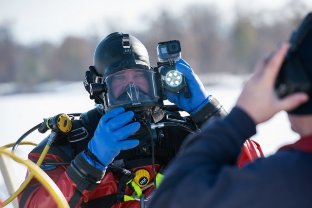 A firefighter with the Directorate of Emergency Services Fire Department dive team prepares equipment for dive training under ice Feb. 3, 2021, at Big Sandy Lake on South Post at Fort McCoy, Wis. The department conducts surface and dive training with ice-covered lakes on post annually. (U.S. Army Photo by Cedar Wolf, Fort McCoy Multimedia-Visual Information Office)