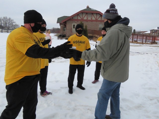 Members of the Fort McCoy, Wis., Army Ten-Miler team prepare to carry an event torch Jan. 29, 2021, as part of the opening ceremony of the Sparta Quest Winter Fest in Sparta, Wis. On Jan. 29, members of the team, along with Command Sgt. Maj. Paul...