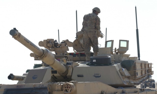 A Soldier from 1st Battalion, 6th Infantry Regiment, 2nd Brigade Combat Team, 1st Armored Division, carries out preventative maintenance checks and services on the top of an M1 Abrams tank, Jan. 29, 2021, to insure it is ready for Iron Union 14 at Al Hamra Training Center in the United Arab Emirates. Iron Union is a recurring, bilateral exercise between Task Force Spartan and the United Arab Emirates Land Forces, designed to strengthen military-to-military relationships through a combined government approach to complex national security challenges. (U.S. Army photo by Staff Sgt. Daryl Bradford, Task Force Spartan Public Affairs)