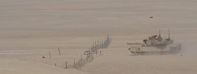 U.S. Army Soldiers from 1st Battalion, 6th Infantry Regiment, 2nd Brigade Combat Team, 1st Armored Division, prepare to steer a M-1 Abrams tank through a simulated breached lane of a mine-wire obstacle during a situational training exercise, Jan. 31, 2021, during Iron Union 14 at Al Hamra Training Center in United Arab Emirates. Events like Iron Union enhance military-to-military partnerships by allowing Soldiers from the U.S. Army and UAE Land Forces to learn the tactics, techniques, and procedures of a key partner and to increase their readiness and interoperability. (U.S. Army photo by Staff Sgt. Daryl Bradford, Task Force Spartan Public Affairs.)