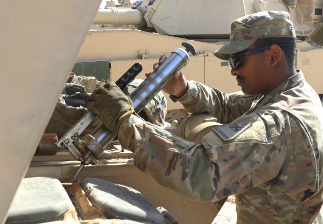 A Soldier from 1st Battalion, 6th Infantry Regiment, 2nd Brigade Combat Team, 1st Armor Division, carries out preventative maintenance checks and services on an M1 Abrams tank, Jan. 29, 2021, to insure it is ready for Iron Union 14 at Al Hamra Training Center in the United Arab Emirates. Iron Union is a recurring, bilateral exercise between Task Force Spartan and the United Arab Emirates Land Forces, designed to strengthen military-to-military relationships through a combined government approach to complex national security challenges. (U.S. Army photo by Staff Sgt. Daryl Bradford, Task Force Spartan Public Affairs)