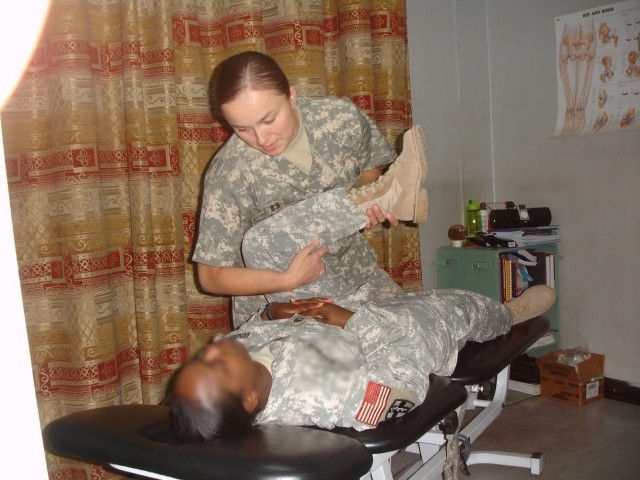 Maj. Barbara Bujak assesses a patient while serving in Iraq in 2009. 