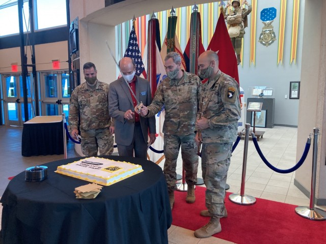 Major General Brian E. Winski, commanding general of the 101st Airborne Division and Fort Campbell, center, prepares to cut a cake Feb. 5 during the Army Emergency Relief campaign kickoff at McAuliffe Hall with Col. Jeremy D. Bell, garrison...