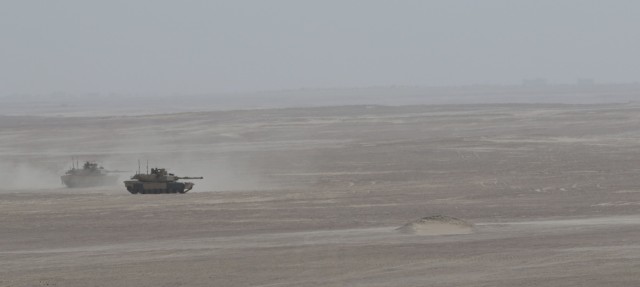 U.S. Army Soldiers assigned to 1st Battalion, 6th Infantry Regiment, 2nd Brigade Combat Team, 1st Armored Division, drive M-1 Abrams tanks toward a simulated breaching of a mine-wire obstacle during a situational training exercise, Jan. 31, 2021, at Iron Union 14 at Al Hamra Training Center in United Arab Emirates. Events like Iron Union enhance military-to-military partnerships by allowing Soldiers from the U.S. Army and UAE Land Forces to learn the tactics, techniques, and procedures of a key partner and to increase their readiness and interoperability. (U.S. Army photo by Staff Sgt. Daryl Bradford, Task Force Spartan Public Affairs.)