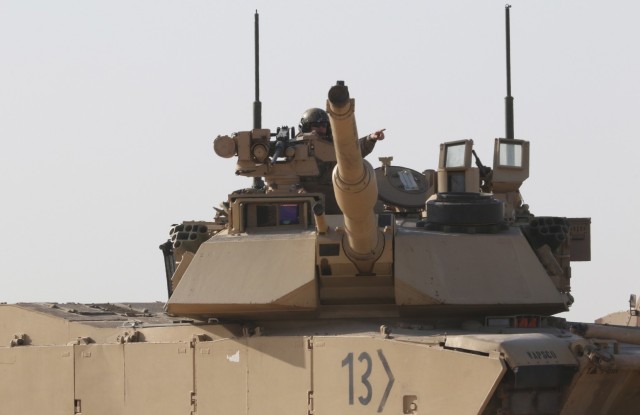A US Army Soldier from 1st Battalion, 6th Infantry Regiment, directs a neighboring tank to the area the M1 Abrams tank he occupies is moving during a Situational Training Exercise, Jan. 30, 2021, for Iron Union 14 at Al Hamra Military Airfield in United Arab Emirates. Iron Union is a recurring exercise that expands partner capacity and supports security cooperation objectives in the Middle East and Southwest Asia. (U.S. Army photo by Staff Sgt. Daryl Bradford)