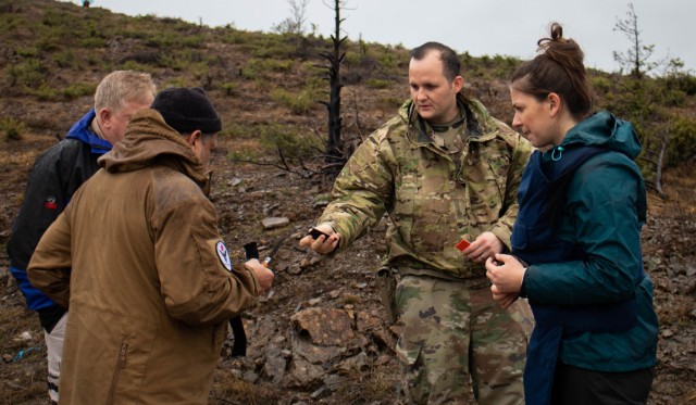 Sgt. Mark Henderson, a Soldier with the 702nd Ordnance Company attached to the EOD team for Regional Command-East, Kosovo Force, gives the tape to a member of Mine Action Kosovo during a MAT Kosovo range day outside Dakovica/Gjakovë, Kosovo, on Feb. 11, 2021. The RC-E EOD team visited the MAT Kosovo range to build cooperation efforts between military and civilian demining organizations. 