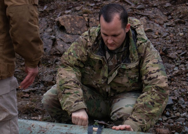 Sgt. Mark Henderson, a Soldier with the 702nd Ordnance Company attached to the EOD team for Regional Command-East, Kosovo Force, helps secure an explosive detonator during a Mine Action Training Kosovo range day outside Dakovica/Gjakovë, Kosovo, on Feb. 11, 2021. The RC-E EOD team supports the NATO-led KFOR to ensure a safe and secure environment for all people in Kosovo.