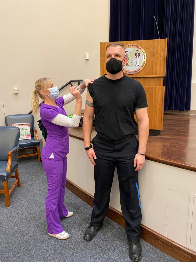 Officer Paul Murphy, a police officer at Natick Soldier Systems Center, receives the first dose of the COVID-19 vaccine.