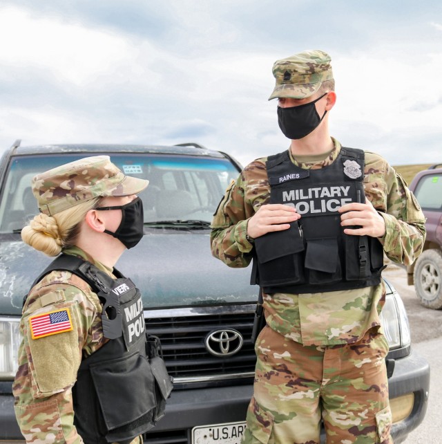 2nd Lt. Allison Vierps, military police officer in charge, and Sgt. 1st Class Michael Raines, provost sergeant, both assigned to Regional Command-East, Kosovo Force 28, discuss Soldier performance during a joint force protection exercise in Kosovo on Jan. 23, 2021. A mock vehicle-born improvised explosive device was detected at the main gate, initiating a cooperative process between military police, security contractors, medical and fire department personnel, and the explosive ordnance disposal team to secure the area and eliminate the threat. Vierps and Raines assessed the effectiveness of the combined efforts to keep service members and civilians on base safe. (U.S. Army National Guard photo by Staff Sgt. Tawny Schmit)