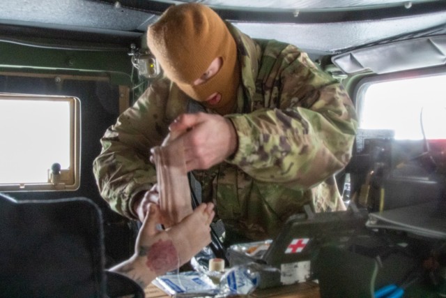 Spc. Parker Sargent provides first aid to motorists on the Turner Turnpike following a wreck near Chandler, Oklahoma. ...