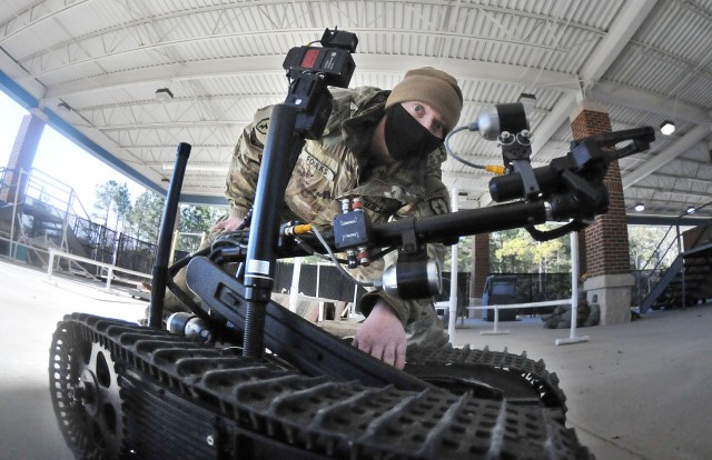 Sgt. Dustin Foulks focuses on the manipulator arm of an explosive ordnance disposal robot during an EOD Specialist Course robotics familiarization Feb. 4 at Rose Hall located on the Ordnance Campus.  During the session, students were required to set up a controller and robot then complete several tasks.