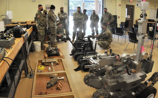 Phase I Explosive Ordnance Disposal Course students listen to Staff Sgt. Daniel Dreibelbis (right, stooping) explain steps in preparing EOD robots for operation during a familiarization class Feb. 4 at Rose Hall. Phase I of the course is seven...