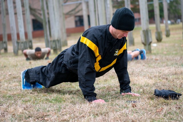 U.S. Army Maj. Timothy Benedict, an Army Public Health Center physical therapist who specializes in injury prevention, leads some APHC Soldiers in push-ups Jan. 31, 2020, at the Aberdeen Proving Ground, Maryland, athletic field as part of their...