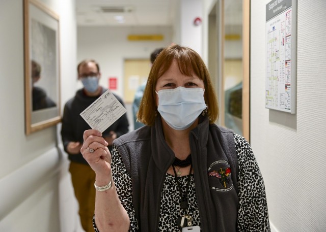 Dr. Barbara Roper, a clinical pharmacist at Army Health Clinic Stuttgart, holds her COVID-19 vaccination record card after receiving her first vaccine on Dec. 31, 2020.