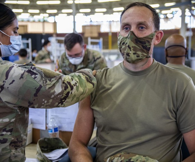 The 402nd Army Field Support Brigade's Command Sgt. Major, Adam Lepley, receives his first dose of the COVID-19 vaccine.