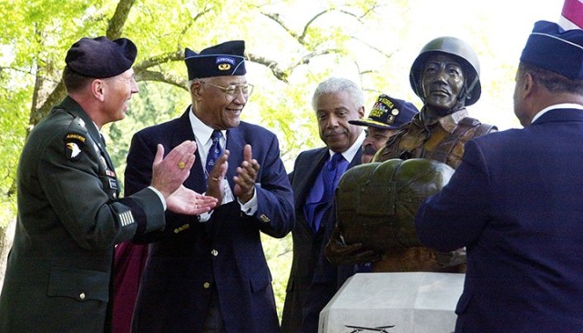 Combined Arms Center and Fort Leavenworth Commander Lt. Gen. David Petraeus and retired 1st Sgt. Walter Morris, one of the original members of the 555th Parachute Infantry "Triple Nickles" Battalion, celebrate the unveiling of a bust honoring members of the first and only all-Black World War II parachute battalion at a dedication ceremony Sept. 7, 2006, at Fort Leavenworth. The bust is located at Smith Lake near the Buffalo Soldier Monument, which was also created by the bust's sculptor Eddie Dixon. The bust was modeled after Morris, who was also the first Black enlisted man accepted for airborne duty. Photo by Prudence Siebert/Fort Leavenworth Lamp