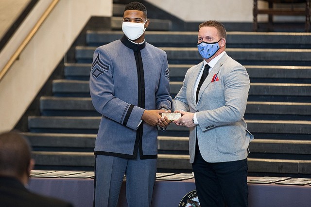 Class of 2022 Cadet and Class President Xavier Williams and a member of the Herff Jones Company hold the gold bar after the 52 rings were melted. The gold bar then becomes part of the legacy gold, which contains trace elements of gold from every...