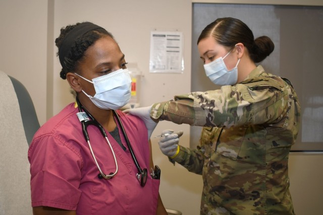 Fort Drum Medical Activity personnel administered the first COVID-19 vaccines Jan. 11. Mary Paul, a nurse with the Bowe COVID-19 treatment clinic and Chicago native, was the very first person to receive the vaccine on post (Photo by Warren Wright, Fort Drum MEDDAC PAO)