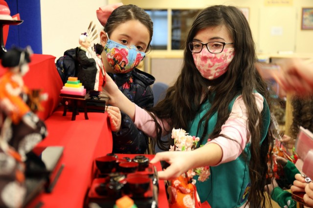 Sophia Fischer, left, 7, a member of Brownie Troop 21, and Layla de Castro, 10, a member of Junior Girl Scout Troop 67, arrange dolls on the “Hinamatsuri” display at the Camp Zama Library, Camp Zama, Japan, Feb. 18.