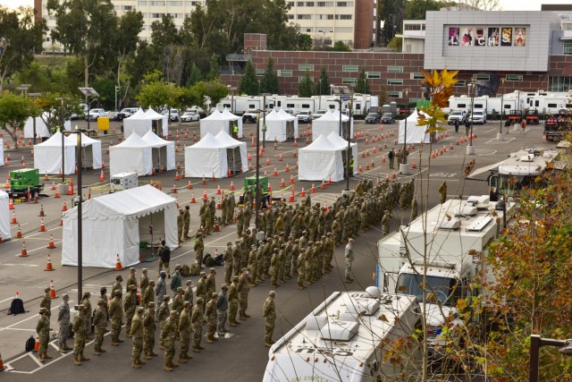 Guardsmen of the California National Guard assigned to Joint Task Force Mustang attend a morning brief at the California State University campus in Los Angeles, Feb. 15, 2021. The force has been activated to support the Federal Emergency...
